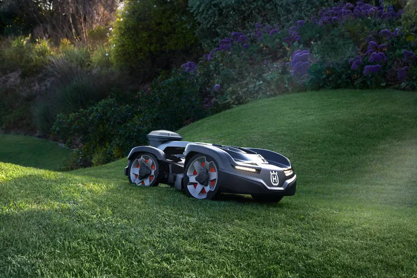 庭の芝生斜面で作業するロボット芝刈り機。